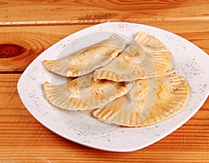 Cooked raviolli on a shiny white plate