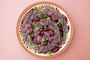 Cooked red beans plate on pink background, isolated. Healthy food