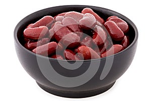 Cooked red kidney beans in a black ceramic bowl isolated on white