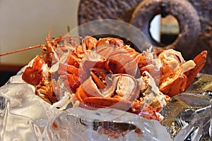 Cooked red lobster prawn with melted herb butter.