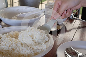 cooked rice in ladle hand held scoop from pot