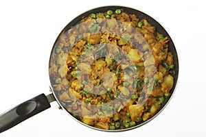 Cooked spicy potato preparation with other vegetables like onion and green peas.