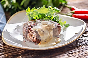 Cooked steak with mushroom sauce and green salad on the side