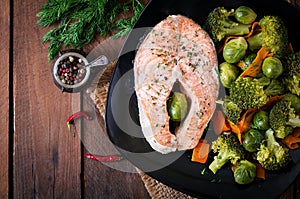 Cooked on steam salmon steak with vegetables.