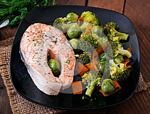 Cooked on steam salmon steak with vegetables.