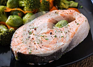 Cooked on steam salmon steak with vegetables.