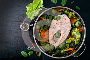 Cooked on steam salmon steak with vegetables.