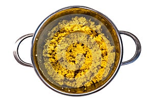 Cooked steamed orange quinoa grits in a pan isolated on white background