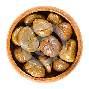 Cooked sweet chestnuts in wooden bowl over white
