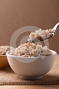 Cooked Thai brown rice in a bowl with spoon