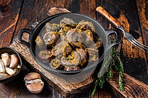 Cooked turkey hearts offals with herbs. Dark wooden background. Top view