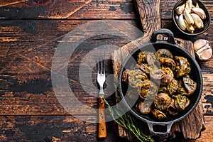 Cooked turkey hearts offals with herbs. Dark wooden background. Top view. Copy space