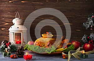 Cooked Turkey for thanksgiving, decorated with branches, berries. Large lantern and candles. Copy space