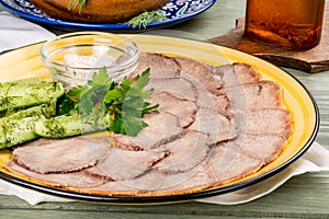 Cooked veal tongue with fresh vegetables. Shot in the decor