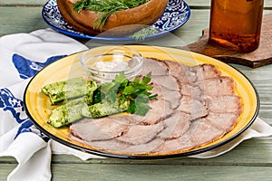 Cooked veal tongue with fresh vegetables. Shot in the decor