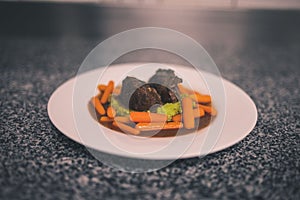 Cooked vegetables with ribs on whoite table on marble surface