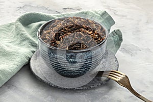 Cooked wild black rice in a bowl, with a fork