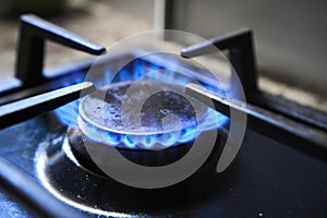 Cooker as heater. Wastage of natural resources. Blue flame from gas hob produce greenhouse gas emissions. Kitchen stove