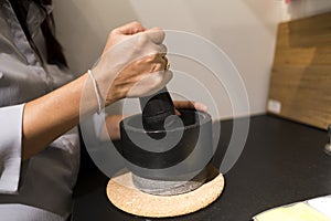 cooker hands pounding something using mortar and pestle