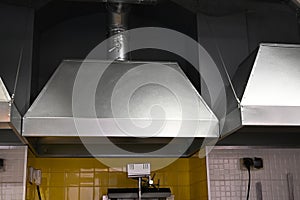 Cooker hood over a stove over a stove in a restaurant