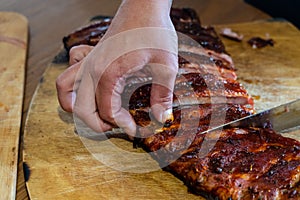 Cooker's hand cut tasty smoked pork ribs on wooden desk