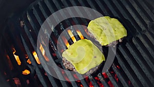 Cookery. cooking burgers. Close-up. grilling of fresh meat burger patties with yellow melted cheese on brazier. roasting