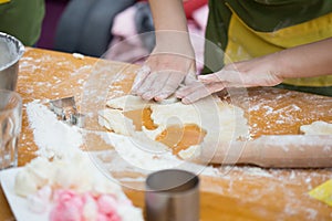 Cookery scene with female hands cutting cookies from raw dough w