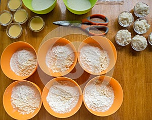 Cookery set of orange and green cups with flour, sugar, yeast an