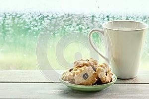 Cookie and coffee cup on rainy day window background