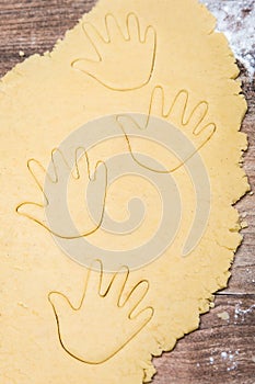 Cookie dough with cutout hand shapes, concept baby is coming