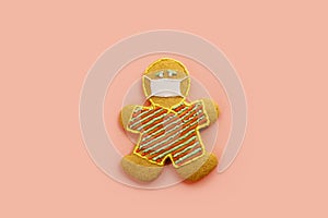 Cookie in the form of a man in a protective mask on a pink background