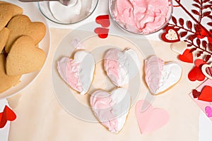 Cookie heart decorated with glaze white and pink for Valentine`s day, close-up, baking for the holiday. decorative hearts top vie