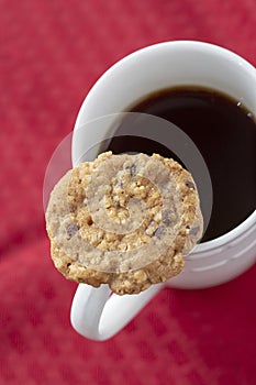 Cookie resting on edge of coffee mug