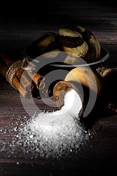 Cookies and barrel small with sugar on a dark wooden background