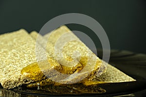 Cookies on a black background are poured with liquid transparent sweet honey on a black background