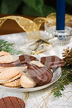 Cookies, blue candle, fir branch, ornaments and pine cone on holiday napkin