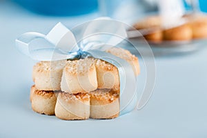 Cookies with blue ribbon on blue background, close up