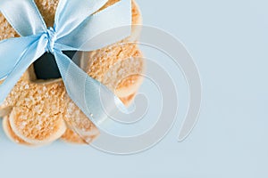 Cookies with blue ribbon on blue background, top view