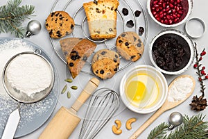 Cookies broken egg in bowl, whisk and sieve, flour and sprigs of fir on table