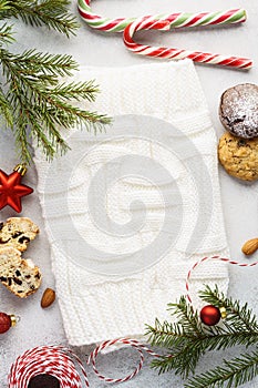 Cookies, candy and decoration around a white knitted fabric