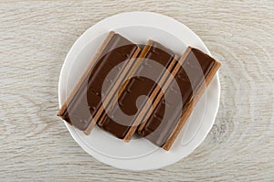 Cookies with chocolate and caramel in plate on wooden table. Top view