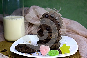 Cookies with chocolate granules served with milk and a little candy are very well served as a morning snack for children, have a