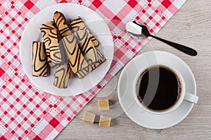 Cookies with chocolate in plate, coffee, spoon, lumpy sugar