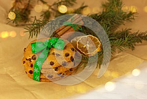 Cookies with christmas green ribbon, lemon, cinnamon and spruce branch on wrapping paper