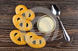 Cookies, condensed milk in bowl, spoon on wooden table