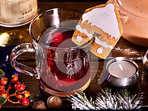 Cookies form of house decorated with glass mug hot drink.