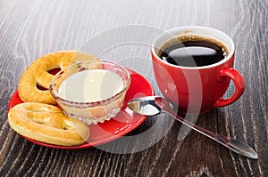 Cookies, condensed milk in bowl on saucer, spoon, coffee