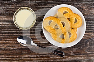 Cookies in saucer, condensed milk in bowl, spoon on table