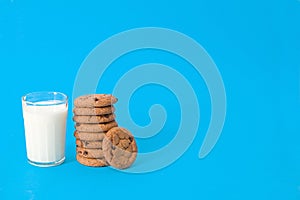 Cookies and glass of milk on blue background. oatmeal cookie with pieces of chocolate