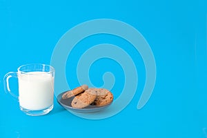 Cookies and glass of milk on blue background. oatmeal cookie with pieces of chocolate